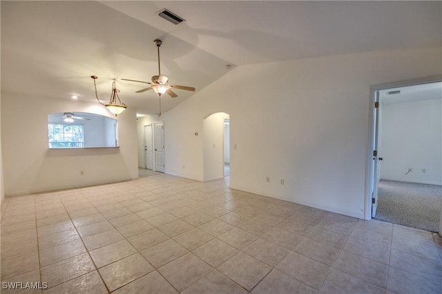 empty room featuring ceiling fan, light tile patterned floors, and vaulted ceiling