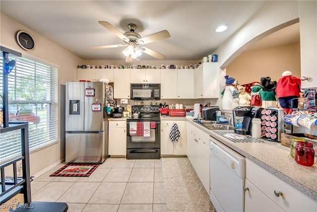 kitchen with black appliances, sink, ceiling fan, light tile patterned floors, and white cabinetry