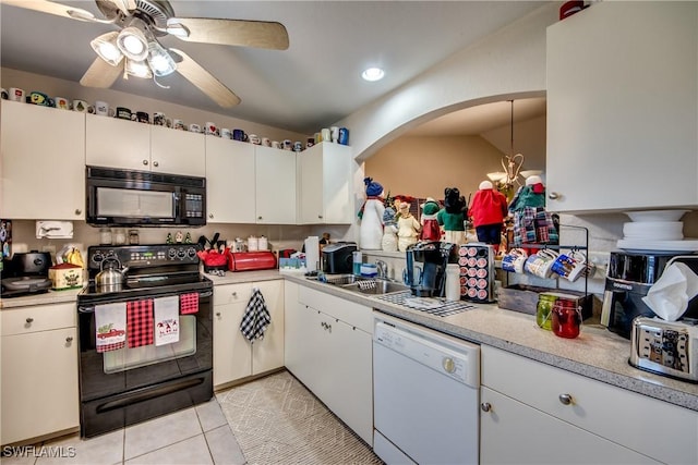 kitchen with white cabinetry, sink, vaulted ceiling, light tile patterned flooring, and black appliances