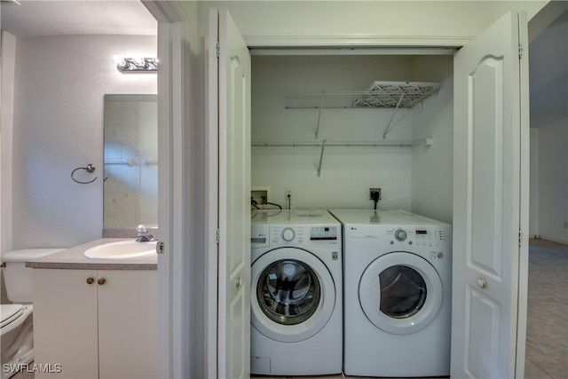 clothes washing area featuring tile patterned flooring, washing machine and dryer, and sink