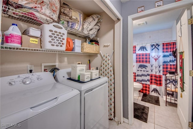 laundry room featuring washer and clothes dryer and light tile patterned floors