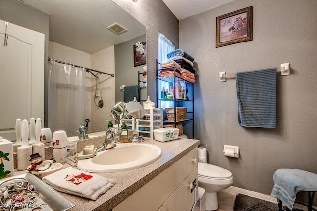 bathroom featuring curtained shower, vanity, and toilet