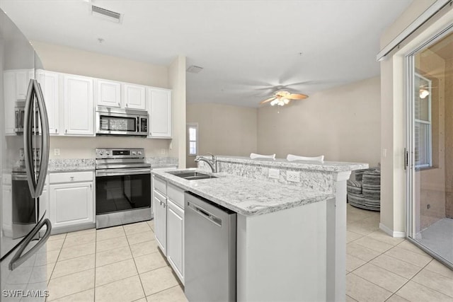 kitchen featuring sink, light tile patterned flooring, white cabinets, and appliances with stainless steel finishes