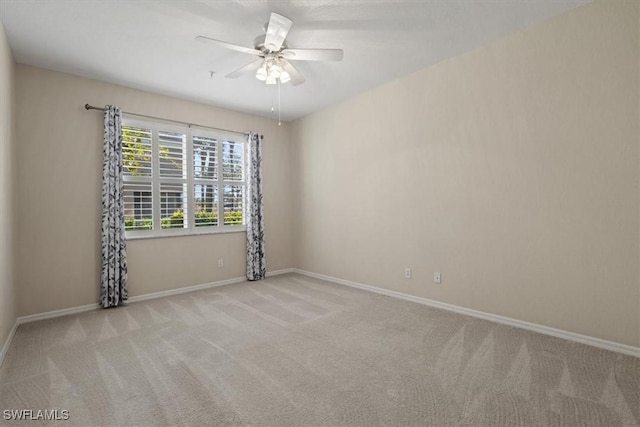 empty room featuring light colored carpet and ceiling fan