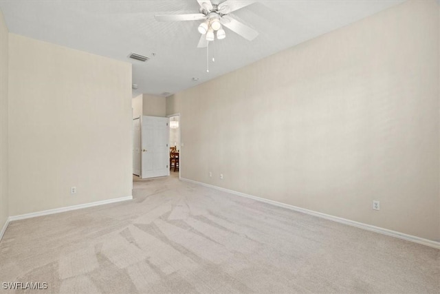 spare room with ceiling fan and light colored carpet