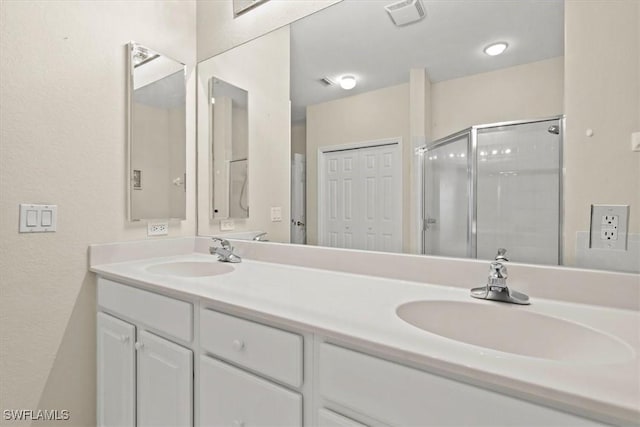 bathroom featuring vanity and a shower with door