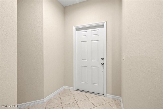 doorway to outside with light tile patterned floors