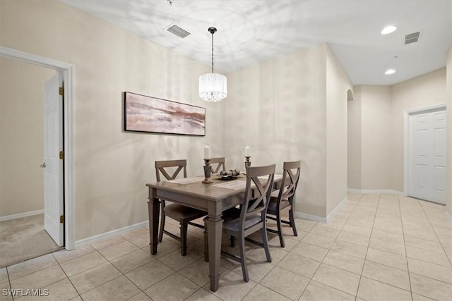 dining space featuring light tile patterned floors and a notable chandelier