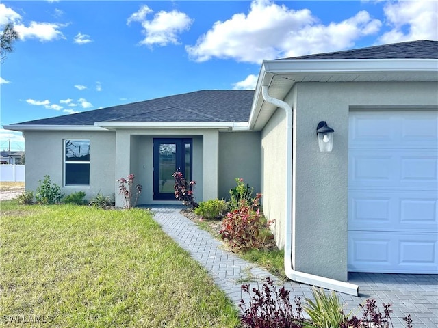 doorway to property featuring a garage and a yard