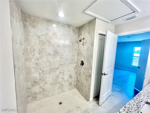 bathroom featuring tile patterned floors and a tile shower