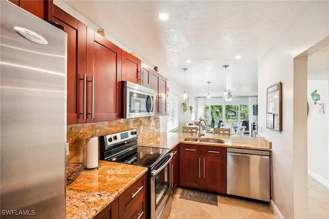 kitchen with ceiling fan, sink, stainless steel appliances, light stone counters, and backsplash