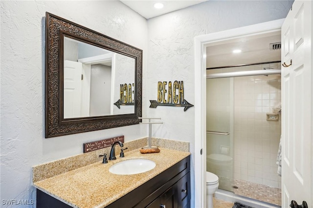 bathroom featuring vanity, toilet, and a shower with door