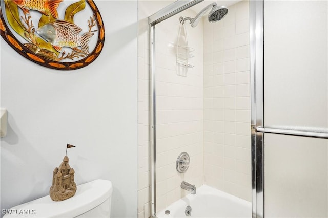 bathroom with toilet and tiled shower / bath