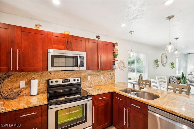 kitchen with sink, hanging light fixtures, tasteful backsplash, kitchen peninsula, and stainless steel appliances