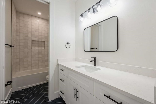 full bathroom featuring toilet, tile patterned flooring, tiled shower / bath, and vanity