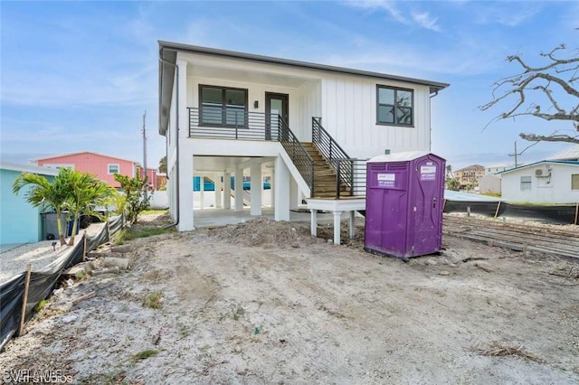 view of front of property with board and batten siding and stairway