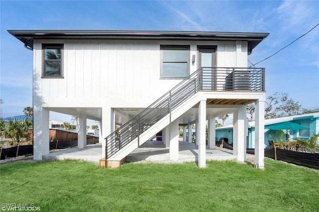 rear view of house with a yard, a patio, and stairs