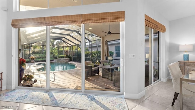 doorway featuring ceiling fan and light tile patterned floors