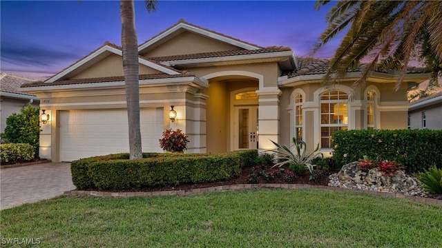 view of front of property featuring a lawn and a garage