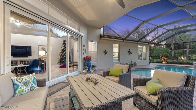 pool at dusk with a lanai, a patio area, and outdoor lounge area