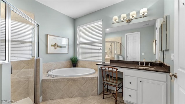 bathroom with plus walk in shower, vanity, tile patterned floors, and a wealth of natural light