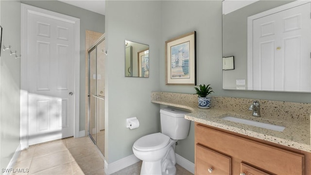 bathroom featuring tile patterned floors, vanity, a shower with shower door, and toilet