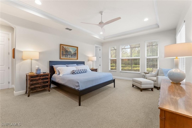 bedroom featuring a tray ceiling, ceiling fan, and light carpet