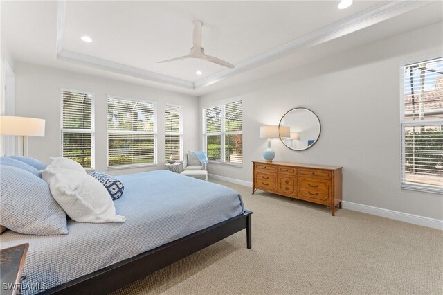 bedroom featuring ceiling fan, a raised ceiling, and light carpet