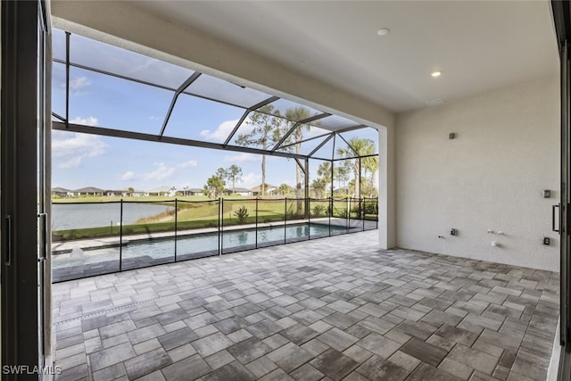 view of patio / terrace with a water view and glass enclosure