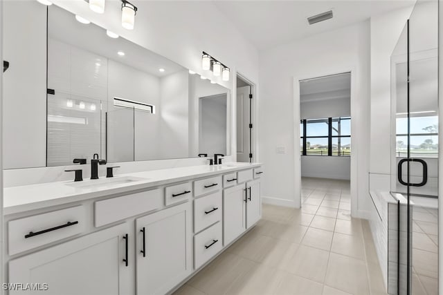 bathroom featuring tile patterned flooring, vanity, and walk in shower