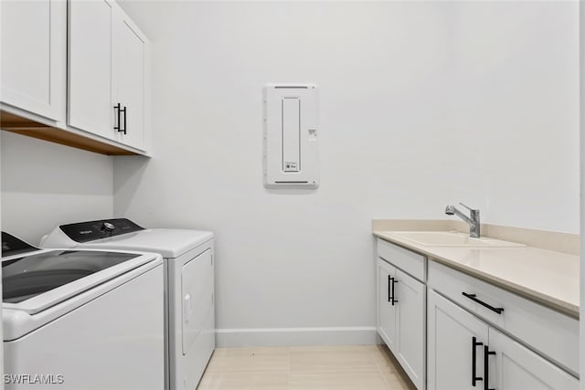 laundry room with washer and clothes dryer, light tile patterned floors, cabinets, and sink