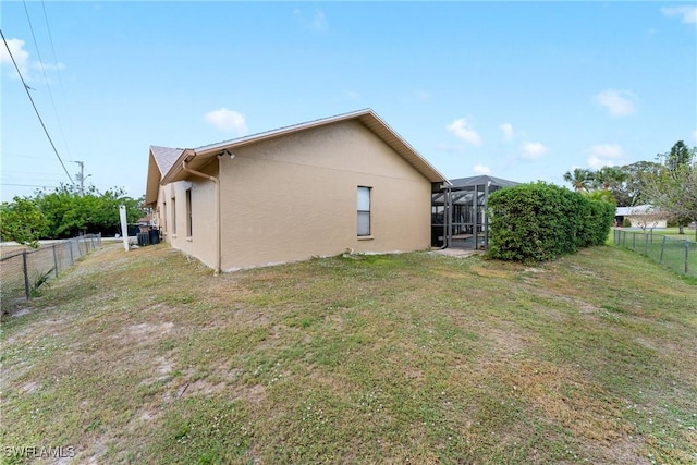 rear view of property featuring a lanai and a lawn