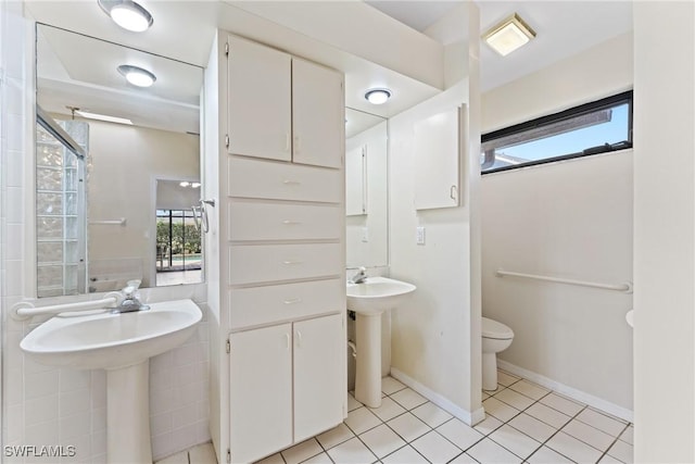 bathroom featuring toilet, tile patterned floors, and sink