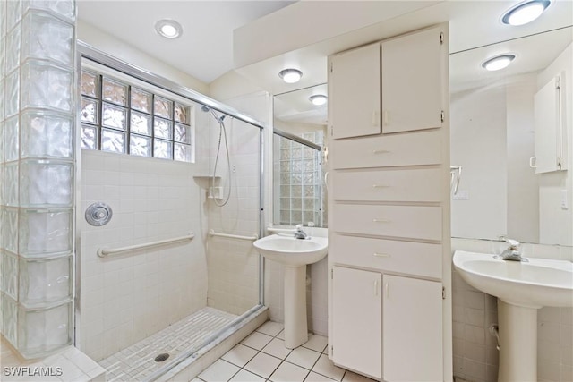 bathroom featuring tile patterned flooring, an enclosed shower, and sink