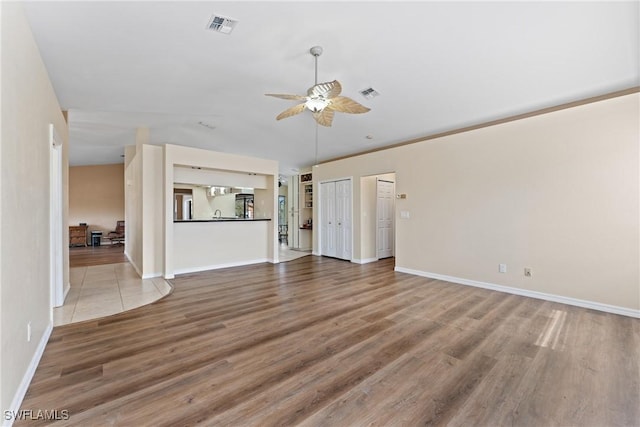 unfurnished living room featuring ceiling fan and wood-type flooring