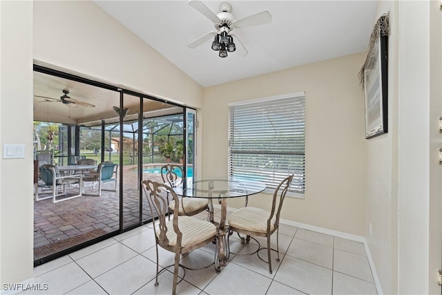 unfurnished dining area with ceiling fan, light tile patterned flooring, and vaulted ceiling