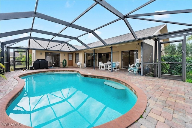 view of pool with a patio and glass enclosure