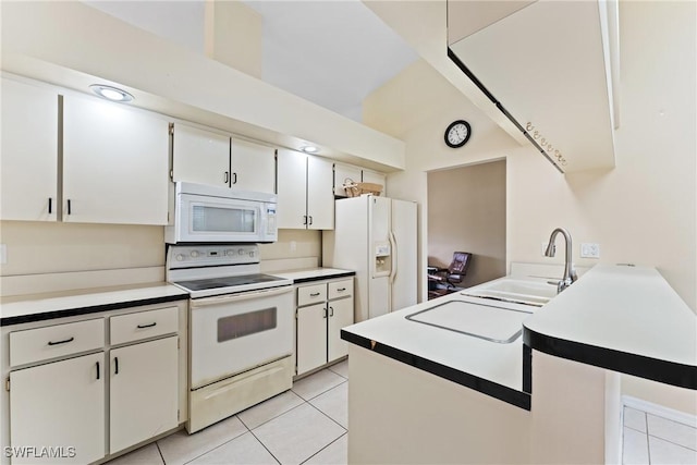 kitchen with kitchen peninsula, white appliances, sink, light tile patterned floors, and white cabinets