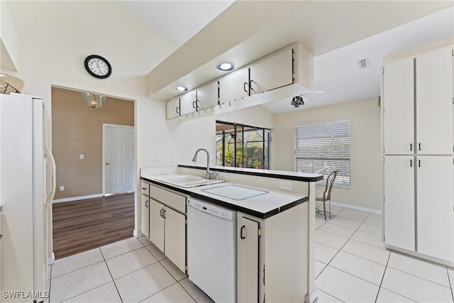 kitchen featuring sink, white cabinets, light tile patterned flooring, and white appliances