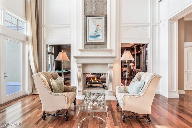 living area with hardwood / wood-style floors and a high ceiling