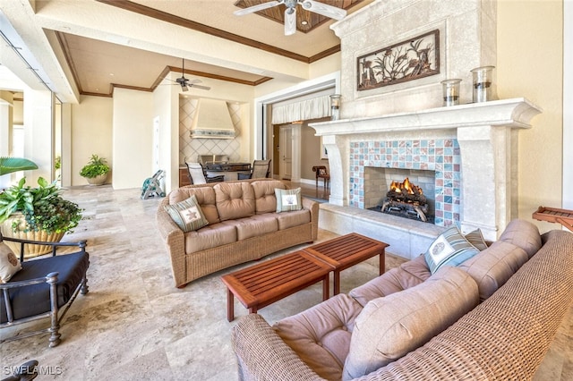 living room with ceiling fan, crown molding, and a fireplace