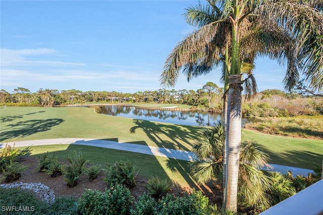 view of home's community with a water view and a yard