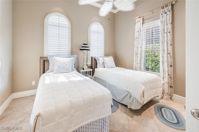 tiled bedroom featuring ceiling fan