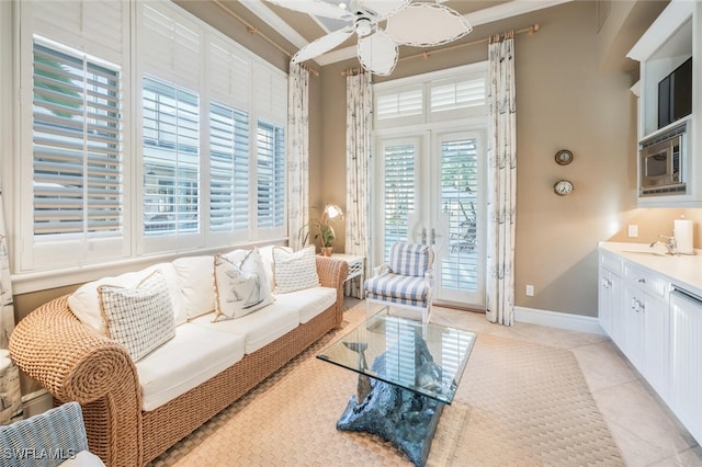 living room featuring sink, ceiling fan, ornamental molding, and light tile patterned flooring