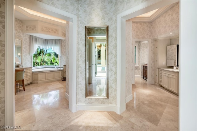 bathroom with crown molding, a bathtub, and vanity