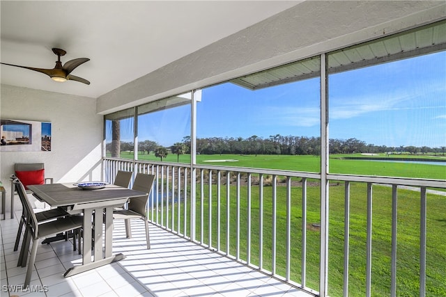 sunroom / solarium featuring ceiling fan, a water view, and plenty of natural light