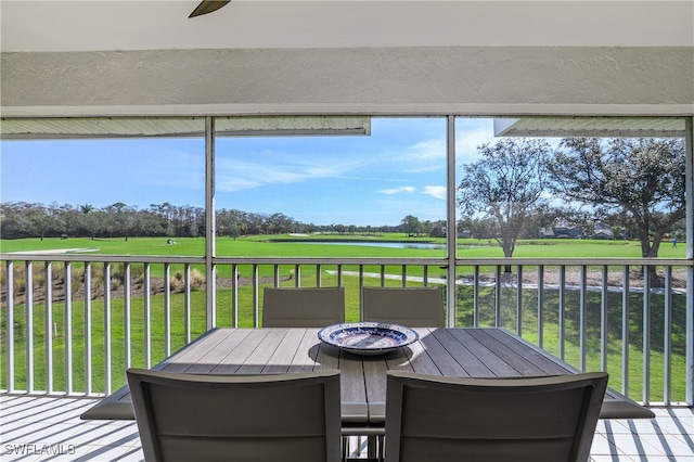 sunroom / solarium featuring plenty of natural light and ceiling fan