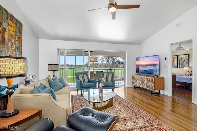 living room featuring ceiling fan, wood-type flooring, and vaulted ceiling