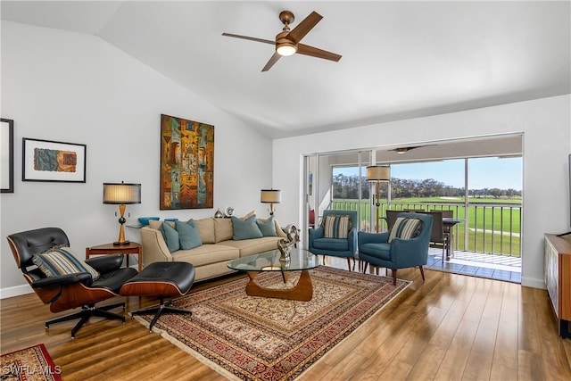 living room featuring ceiling fan, hardwood / wood-style floors, and vaulted ceiling