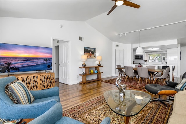 living room featuring hardwood / wood-style floors, track lighting, ceiling fan, and lofted ceiling